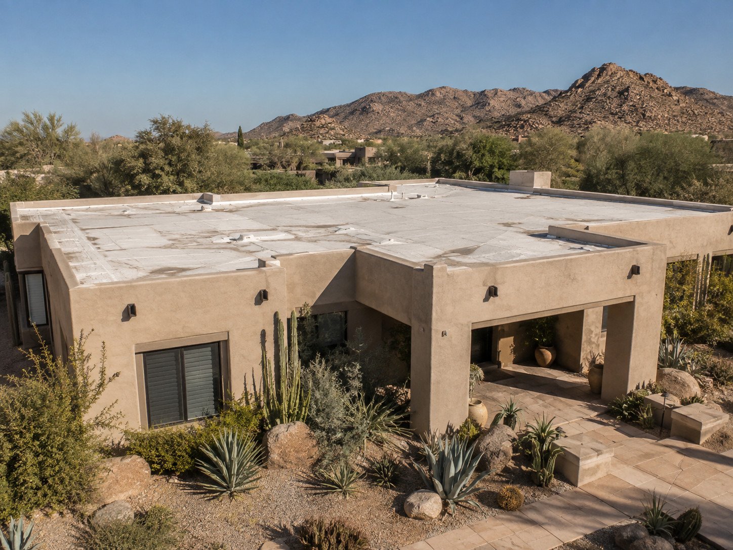 Aerial view of a Southwest home with a weathered spray foam roof showing staining, patching and worn coating