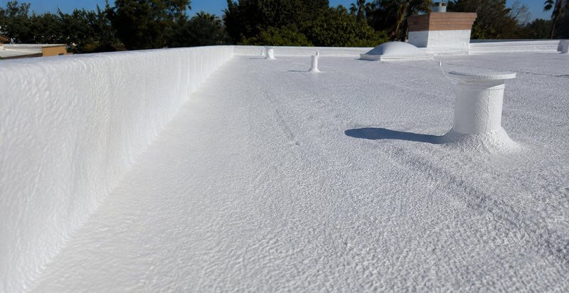 Seamless spray foam coating running up a parapet wall