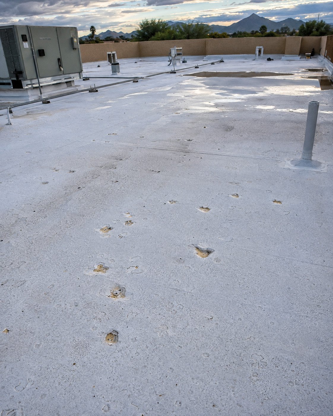 Spray foam roof pocked with hail strikes that broke through the coating to expose tan foam beneath