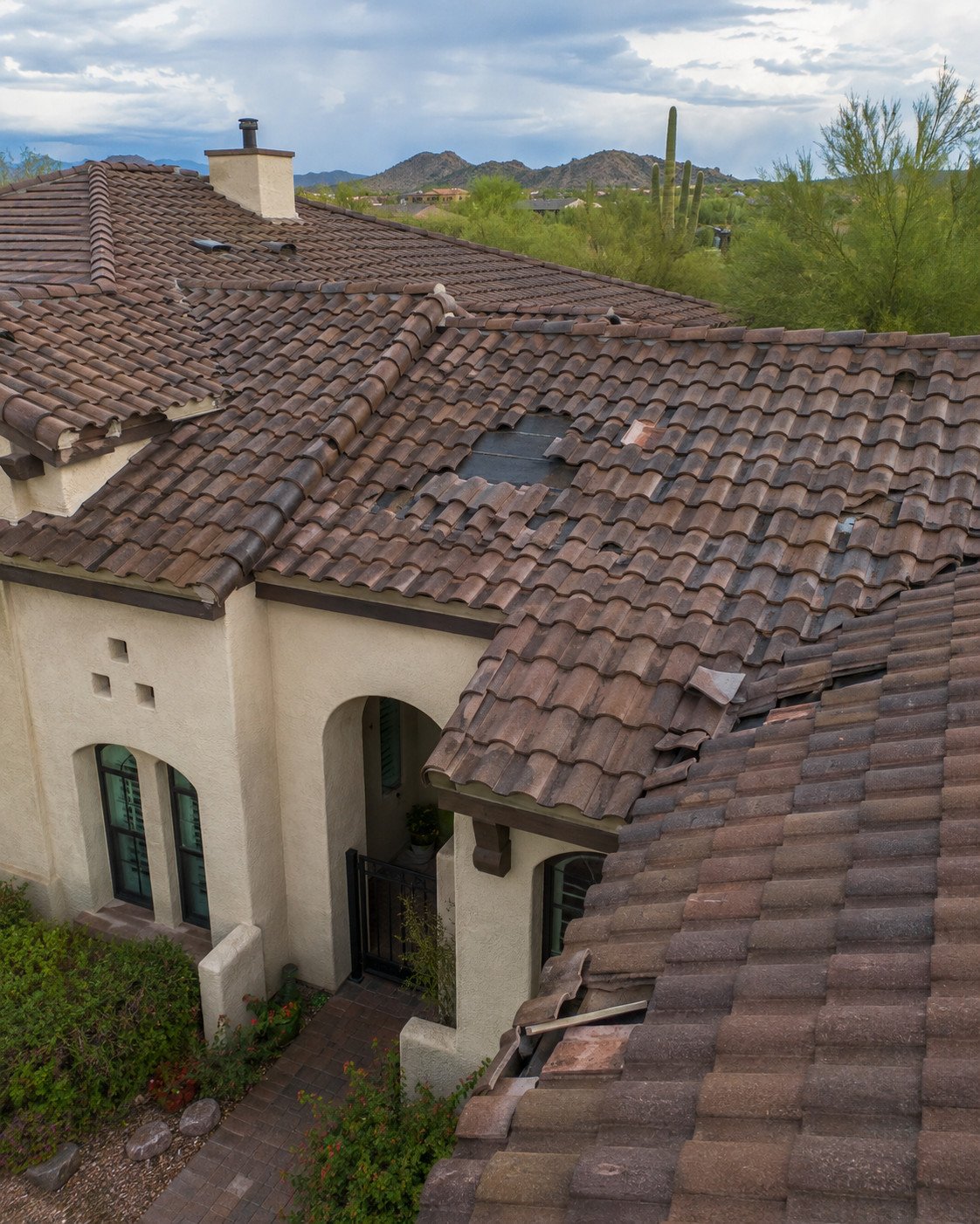 Concrete tile roof after a monsoon, with tiles broken, slipped and missing exposing the underlayment